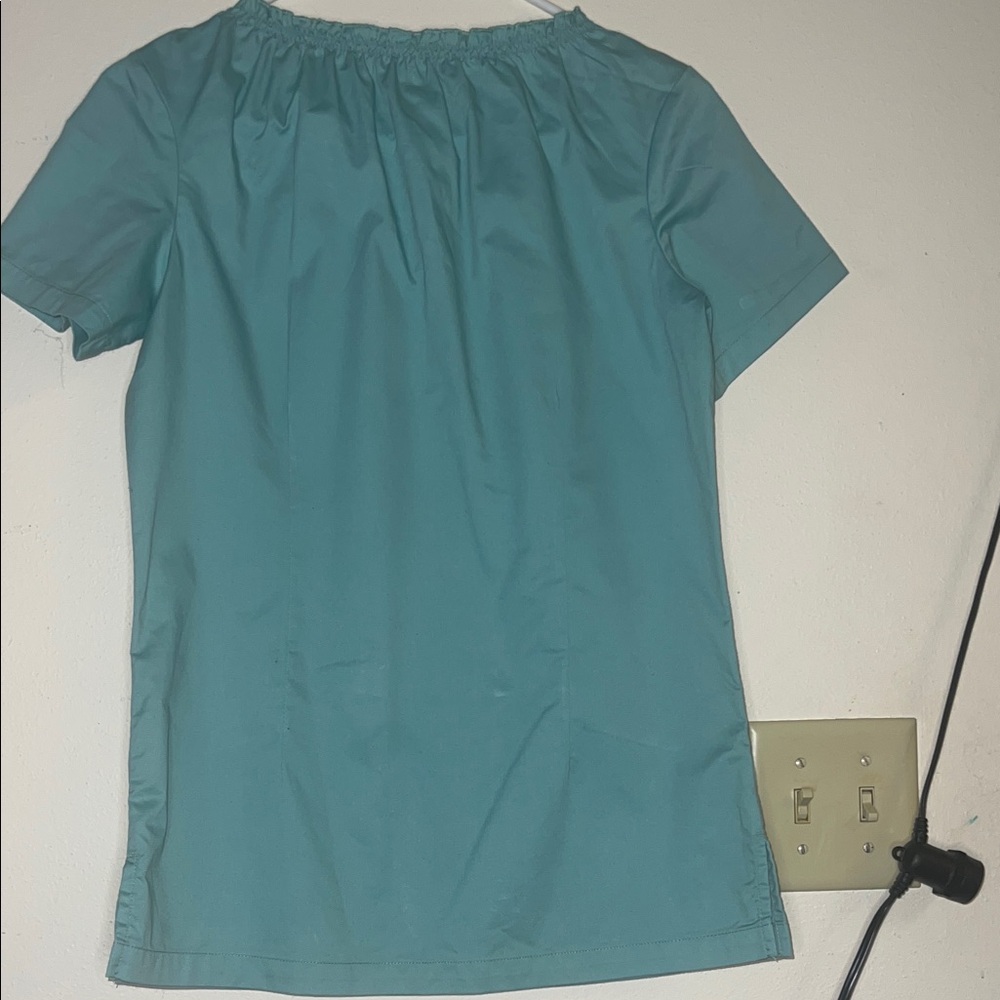 Women's green scrub top is cute with baby doll collar.